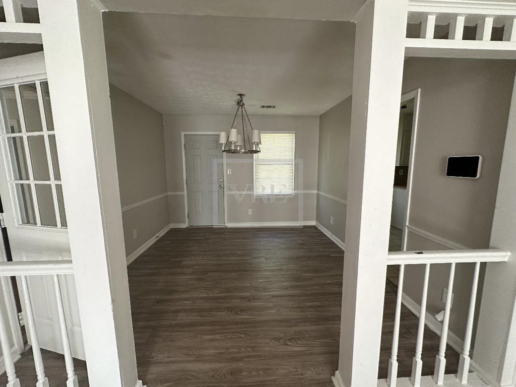 a view of the hallway from the top of the stairs looking into the living room