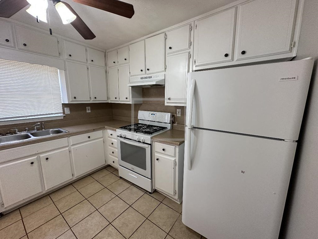 a kitchen with white appliances and white cabinets