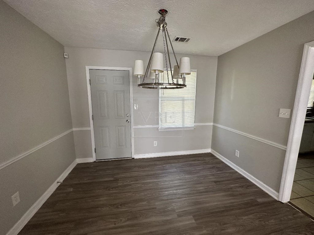 a dining room with a chandelier and a white door