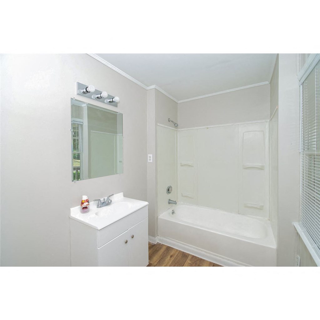 a bathroom with a sink and a shower and a mirror