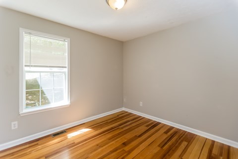 A room with wooden floors and a window.