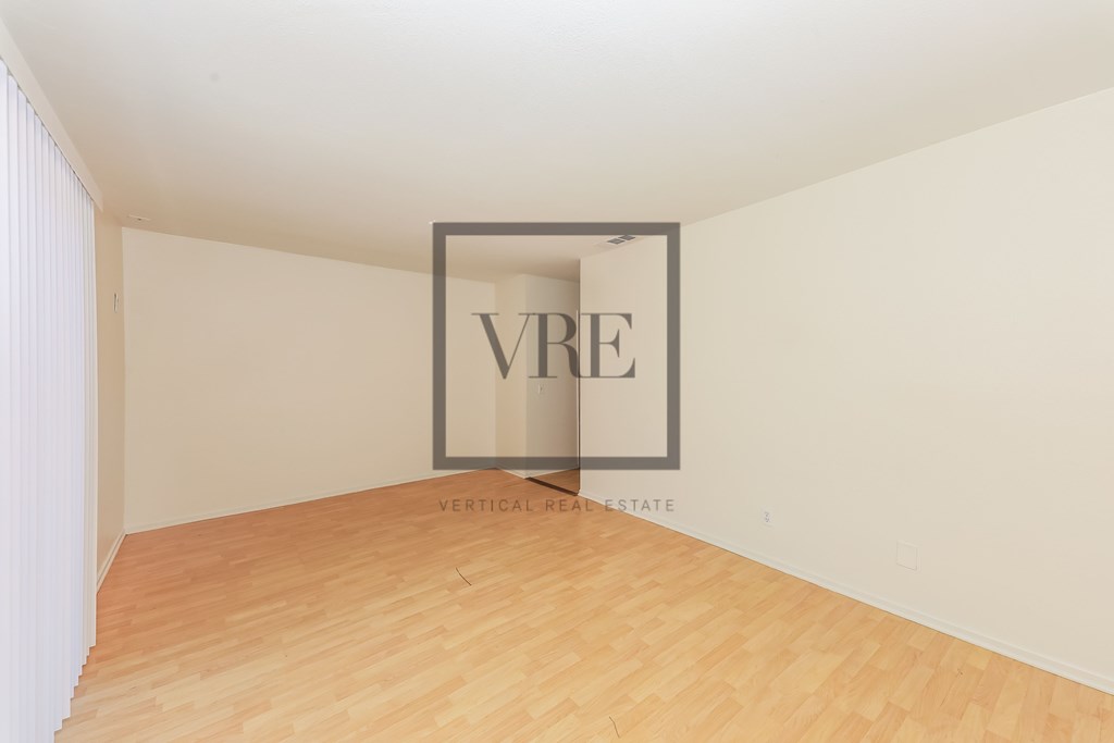 A room with wooden flooring and a white wall with a VRE sign.