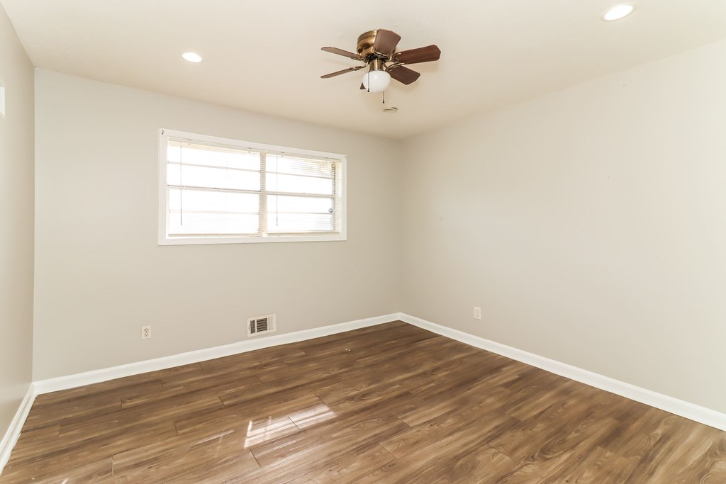 A room with a ceiling fan and a window.