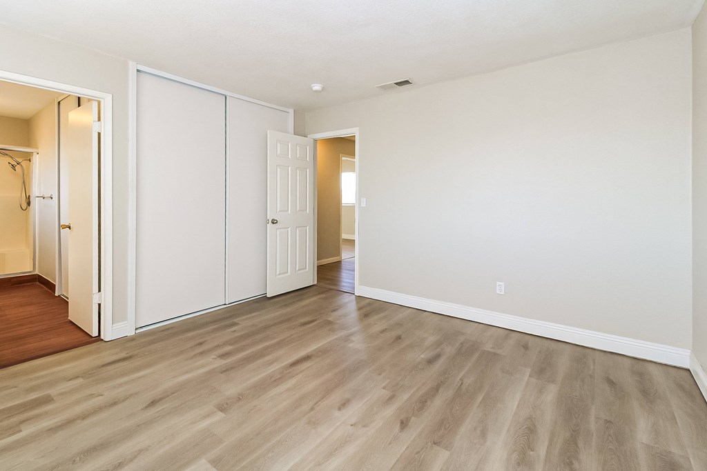 A room with a white wall and a wooden floor.