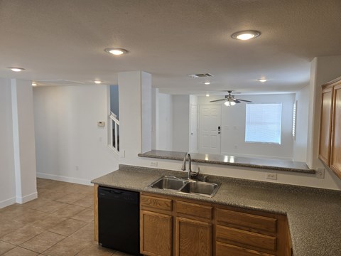 A kitchen with a black dishwasher and a sink.