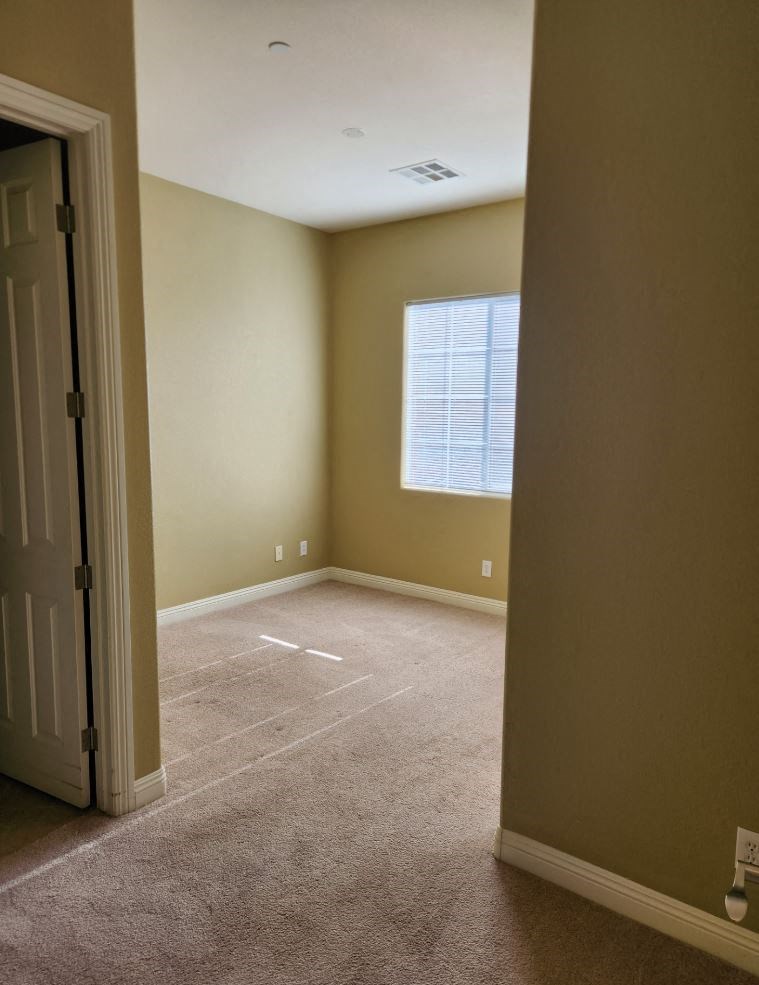 an empty room with a door and a window