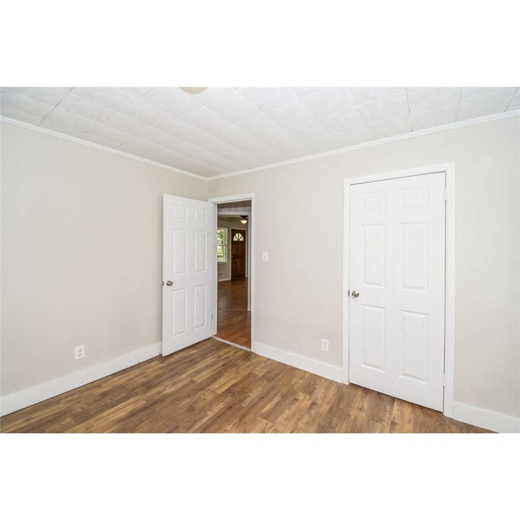a bedroom with two closets and a door to a hallway