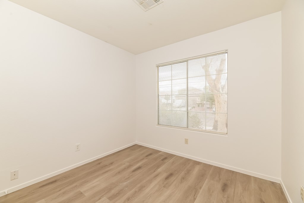 A room with a window and wooden flooring.