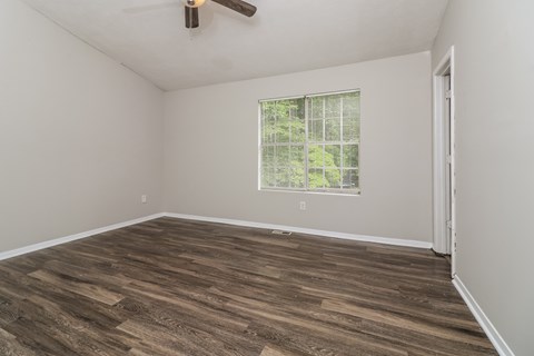 A room with a window and a ceiling fan.