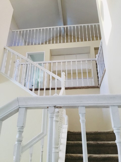 the view down the stairs from the top of a white staircase