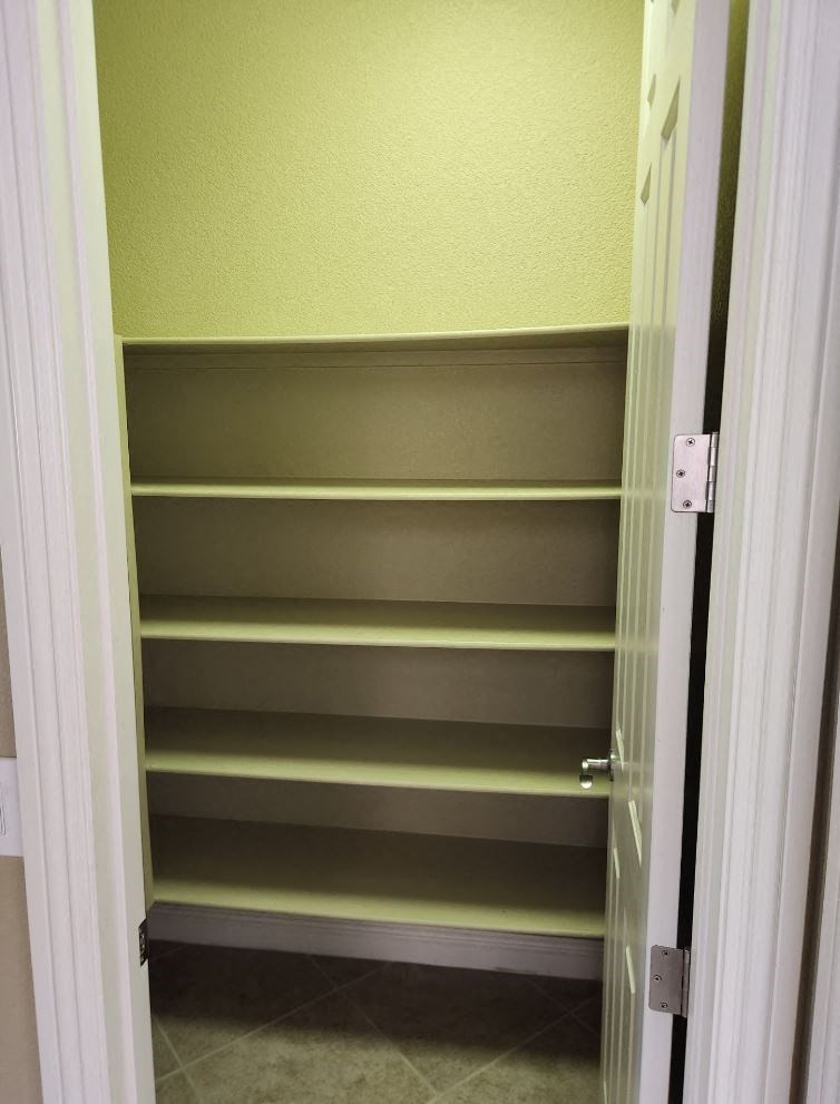the shelves in the closet are empty and the door is open