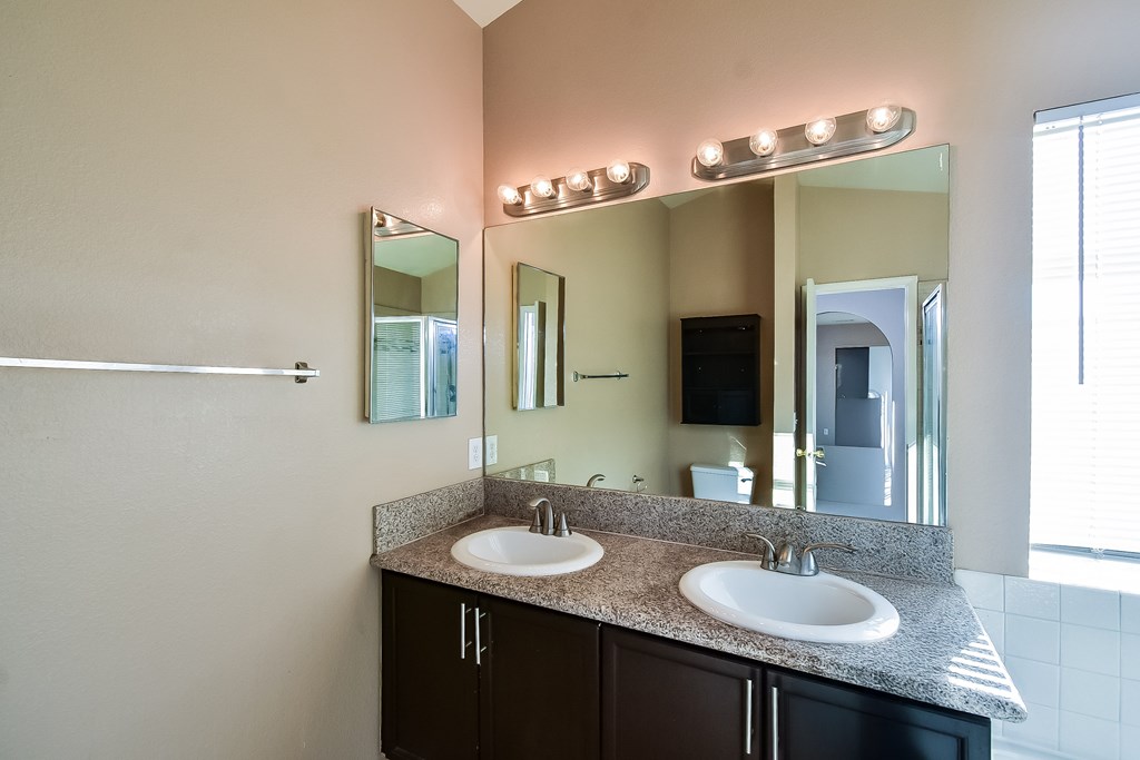 A bathroom with two sinks and a large mirror.
