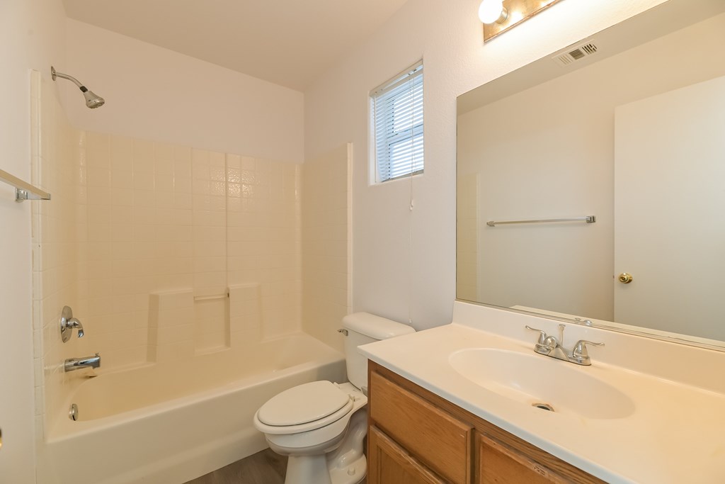 A white bathroom with a toilet, sink, and bathtub.