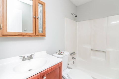A white sink with a wooden cabinet above it.