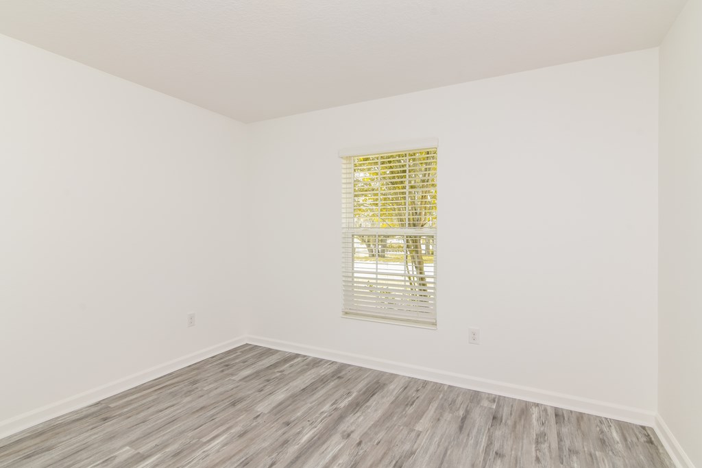 A room with a window covered by blinds.
