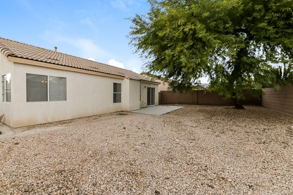 A house with a brown roof and a tree in front.