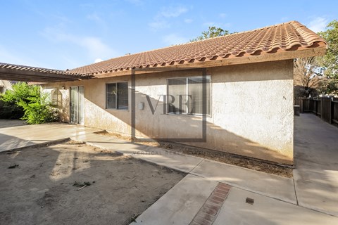 A house with a tiled roof and a sign that says "DRV".