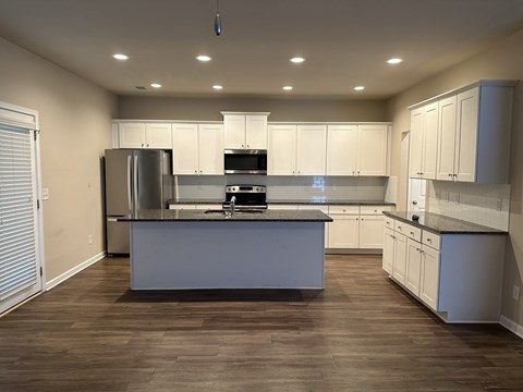 a kitchen with white cabinets and a large island