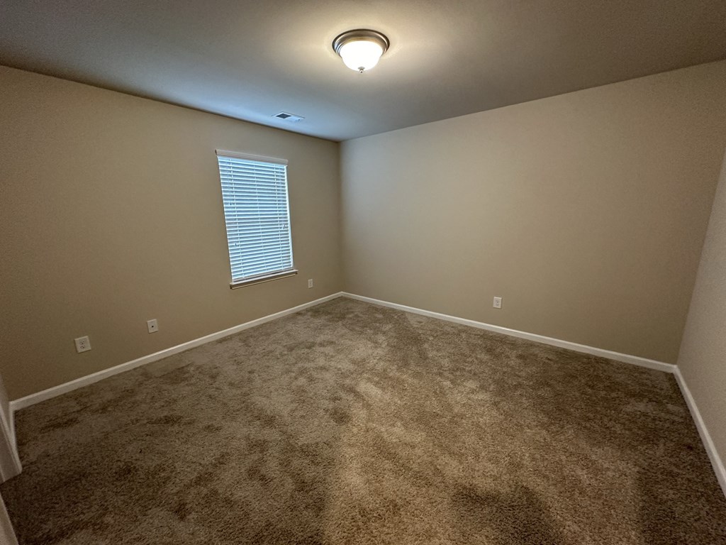 a empty room with carpet and a window