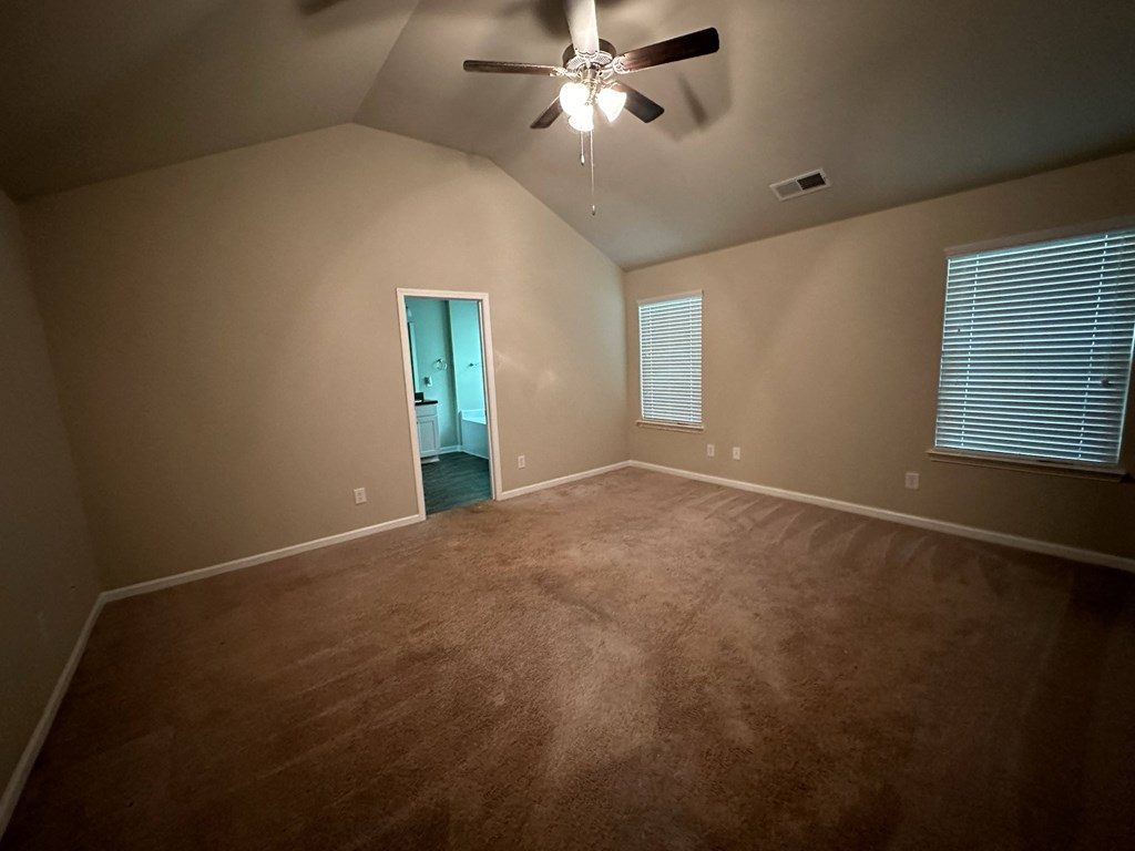 a empty living room with a ceiling fan and a window