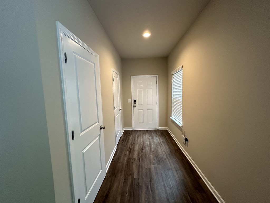 a hallway with white doors and a door to a closet