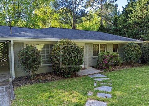 A house with a well-maintained lawn and a stone pathway leading to the front door.