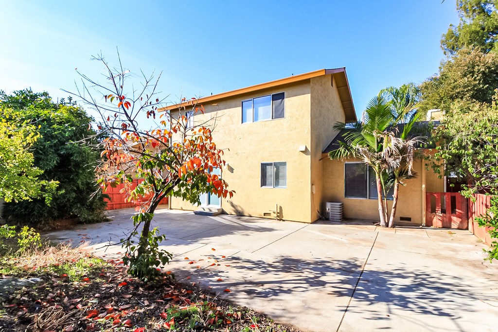 A yellow house with a tree in front of it.