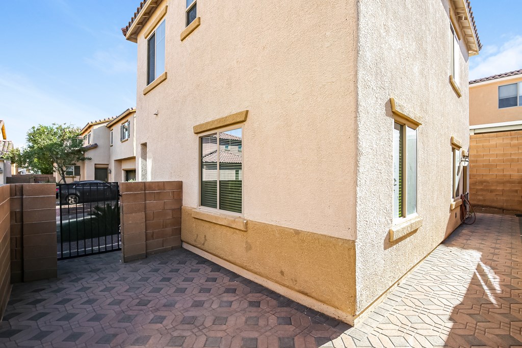 A house with a black gate and a tiled walkway.