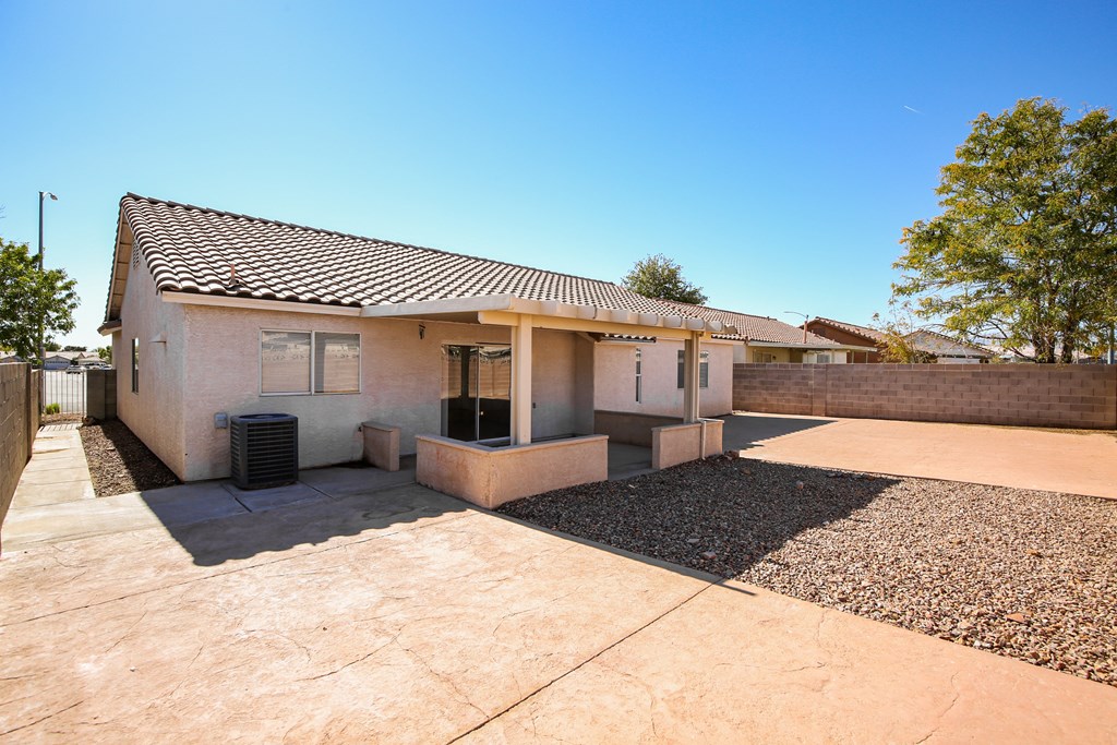 A house with a brown roof and a gravel driveway.