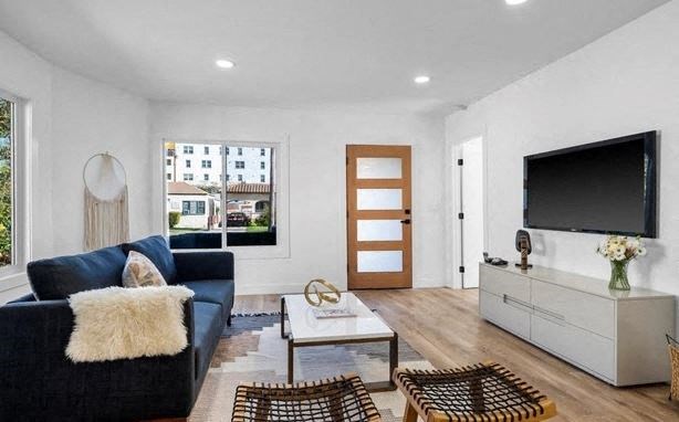 A living room with a blue couch and a wooden door.