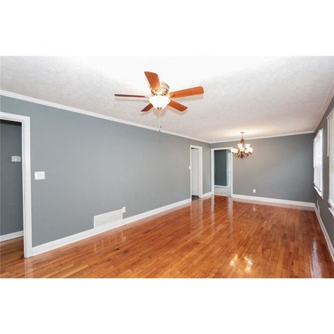 a living room with wood floors and a ceiling fan