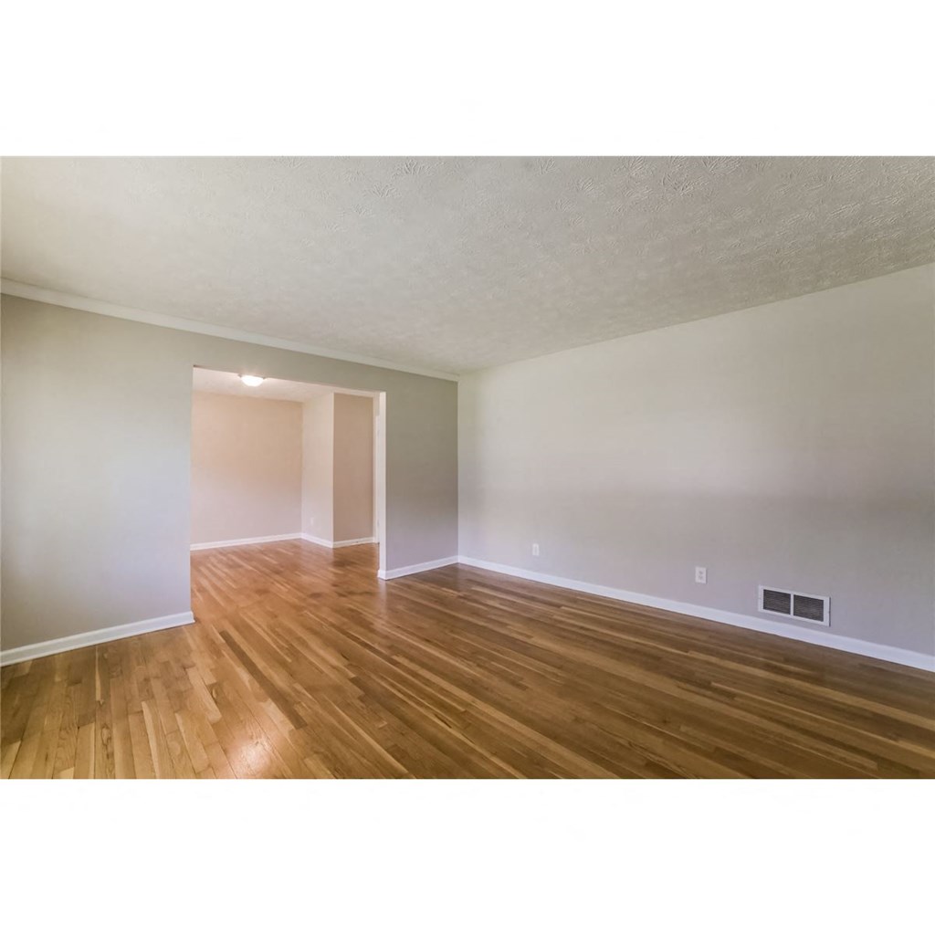 an empty living room with a hard wood floor