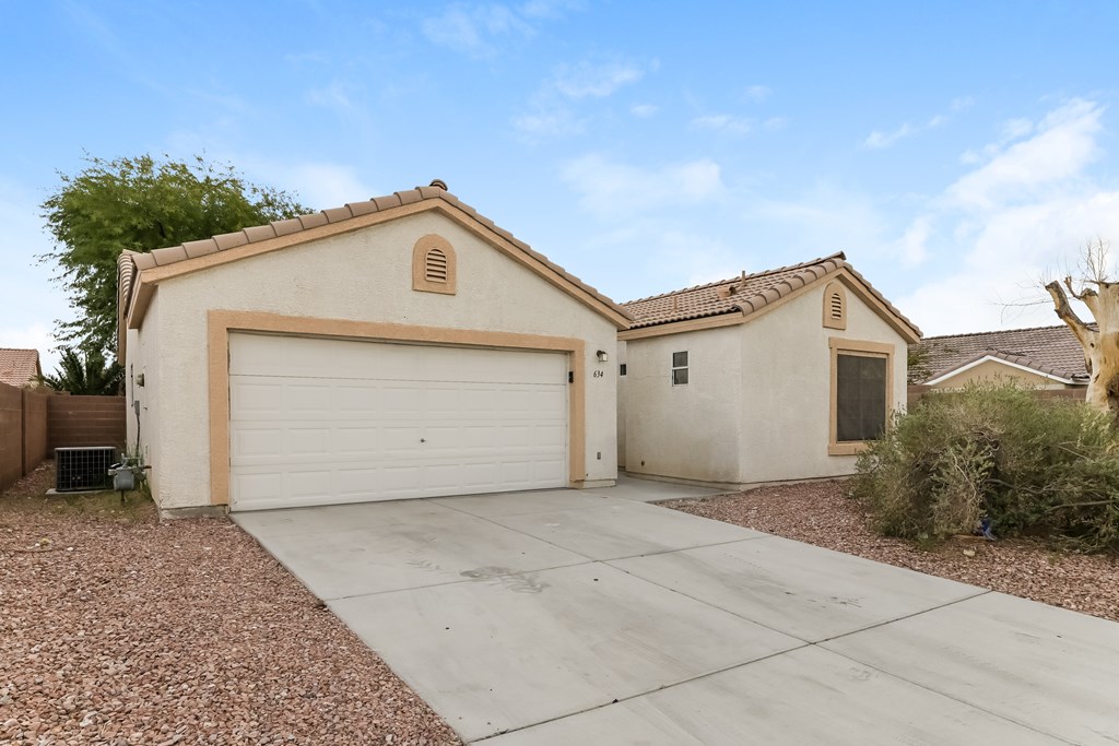 A house with a garage door and a driveway.