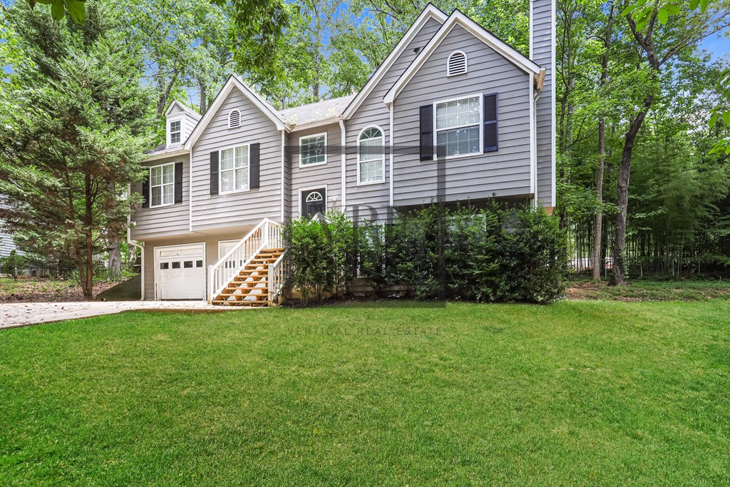 A house with a grey exterior and a white garage door.