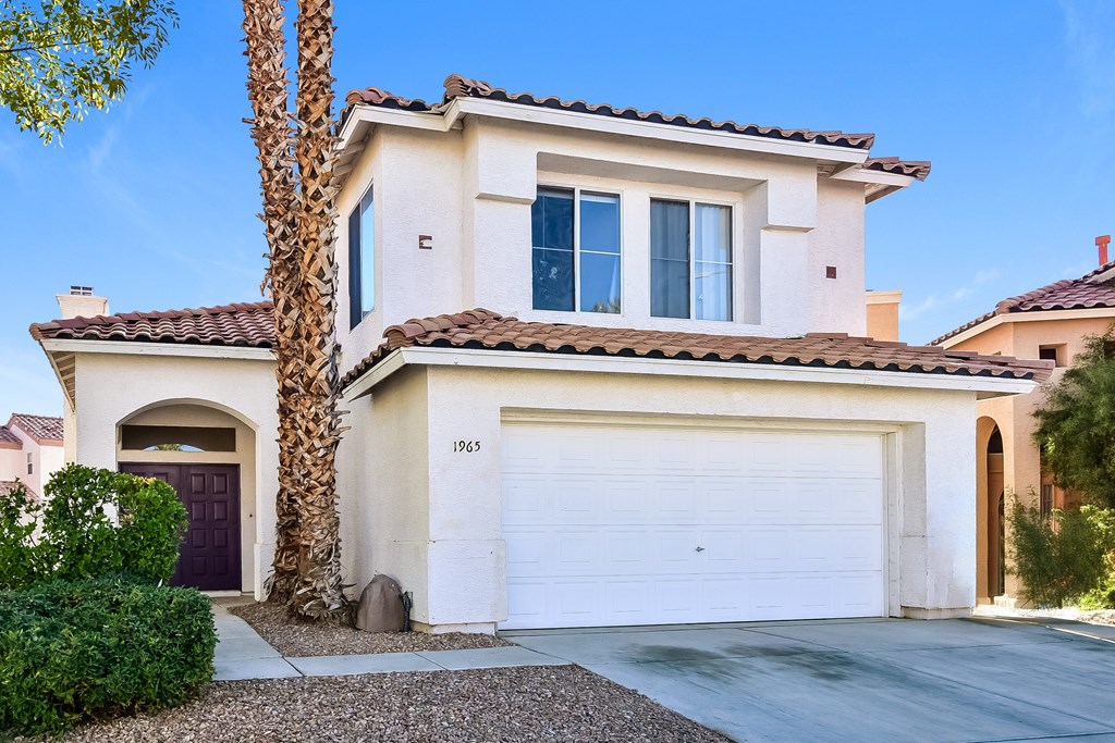 A house with a white garage door and a brown door.