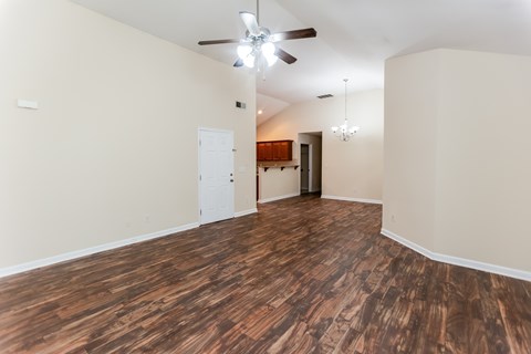 A room with wooden flooring and a ceiling fan.