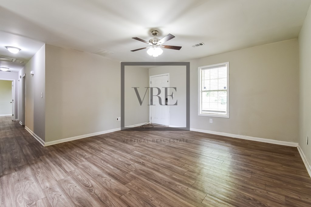 A room with wood flooring and a ceiling fan.
