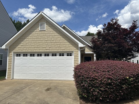the front of a house with a white garage door