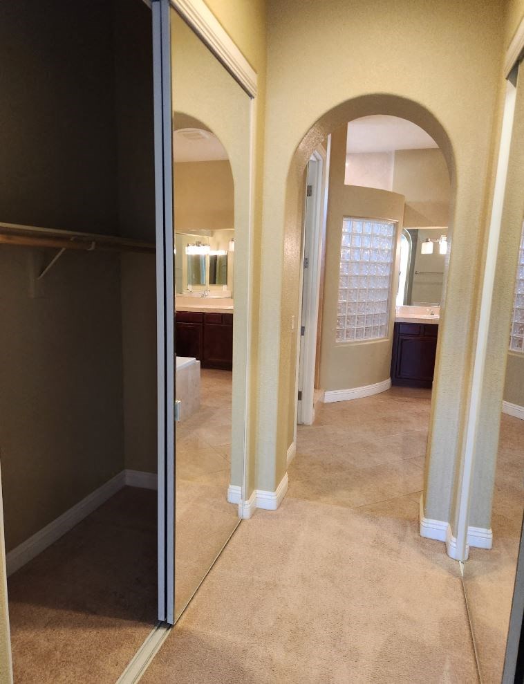 a bathroom with a large mirror and a walk in closet