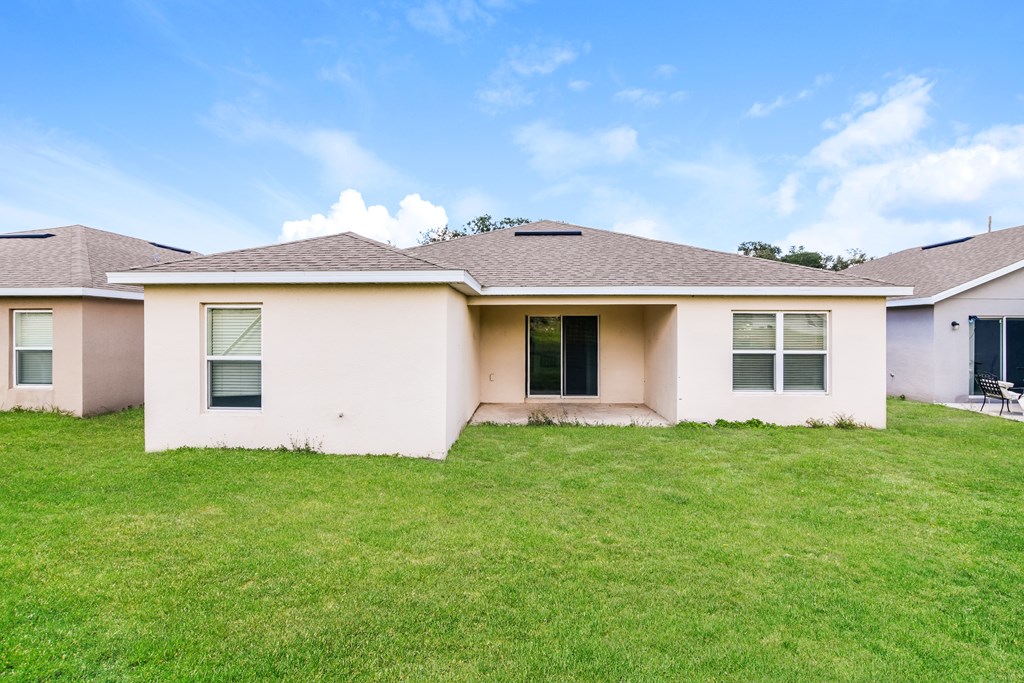A house with a brown roof and a white wall with a window and a door.