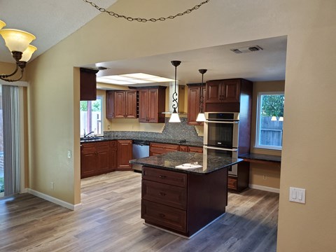 A kitchen with wooden cabinets and a granite countertop.