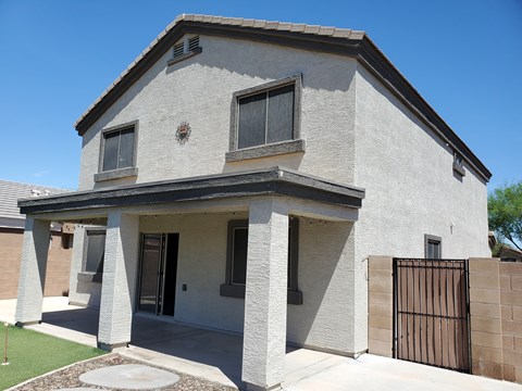 A house with a grey exterior and a black gate.