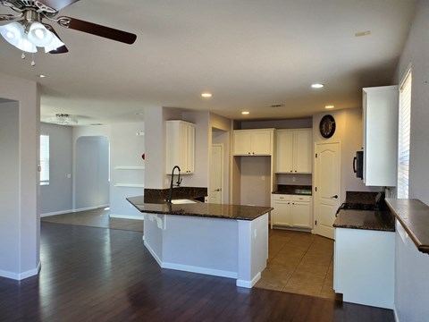 A kitchen with white cabinets and a dark counter top.