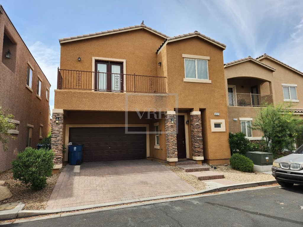 A two-story house with a balcony on the second floor.