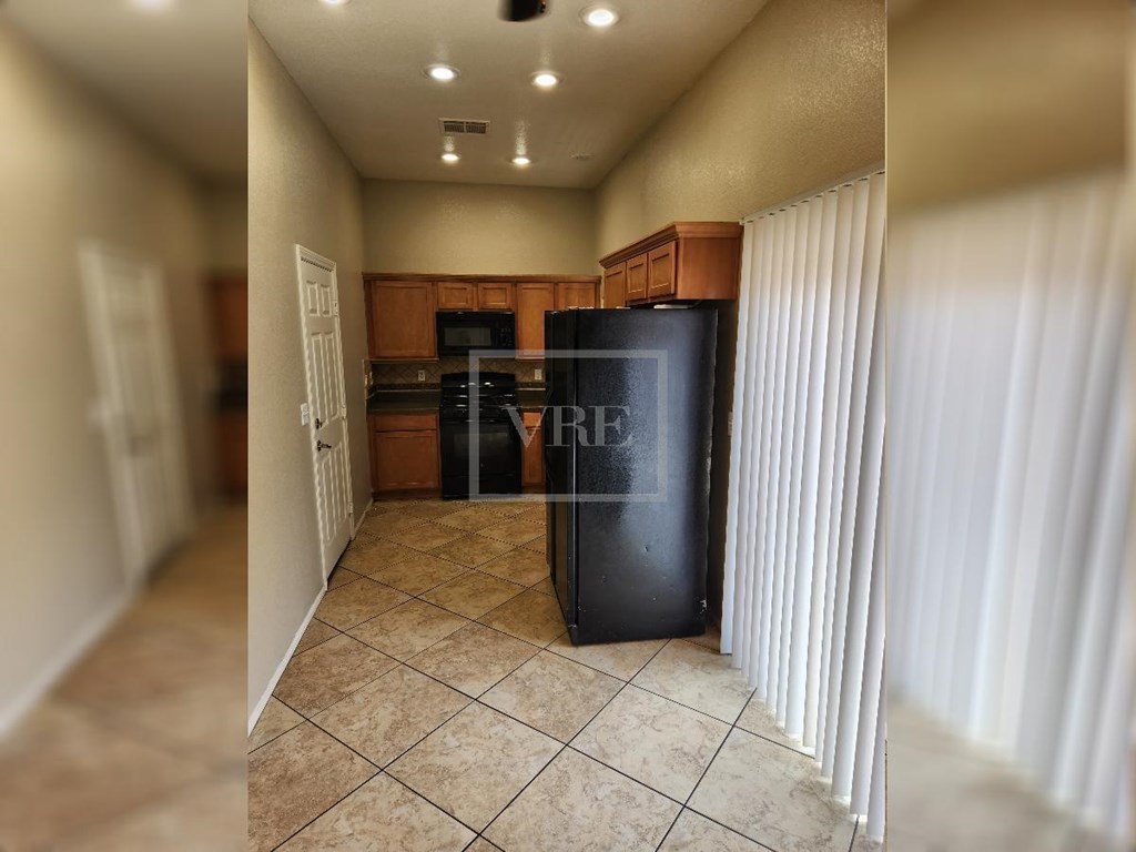 A black refrigerator with the word "FREEZE" on it is in a kitchen.