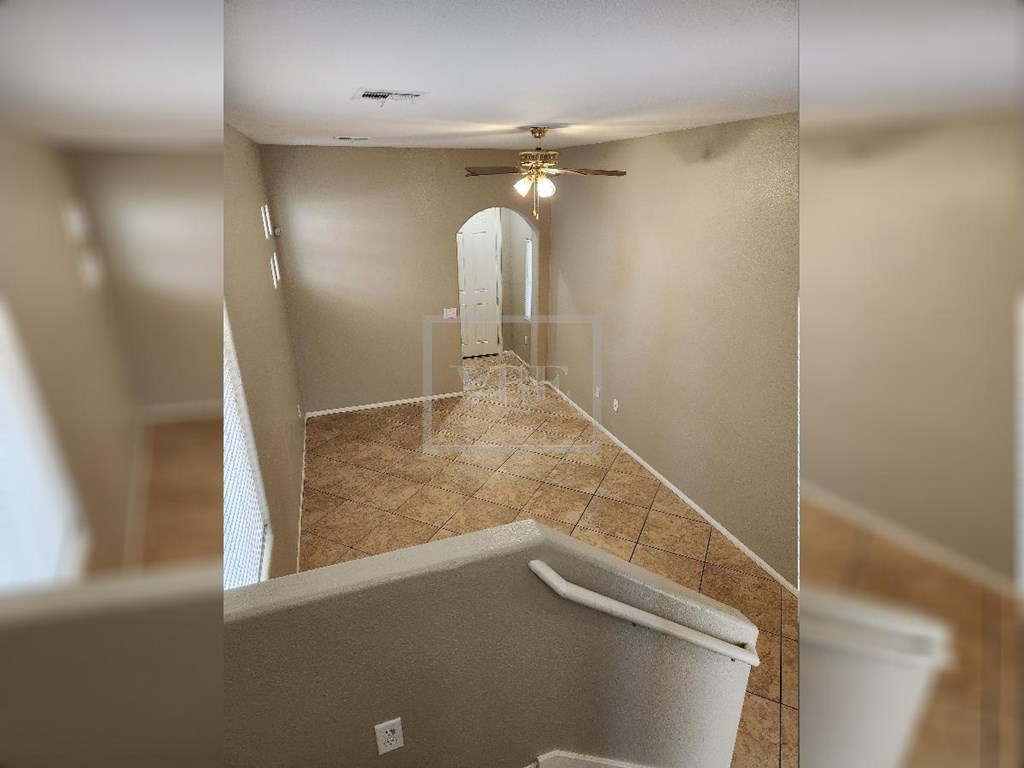 A room with a ceiling fan and a bathtub.