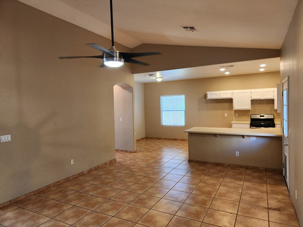a kitchen with a ceiling fan in a empty room