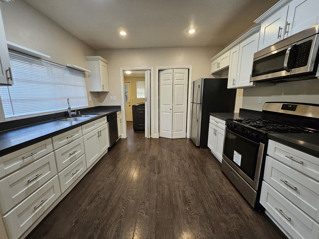 A kitchen with black countertops and white cabinets.