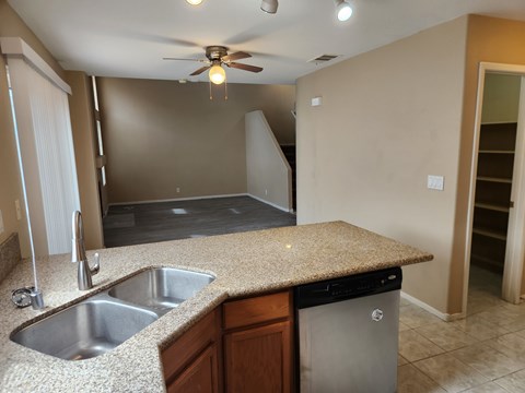 A kitchen with a sink and a ceiling fan.