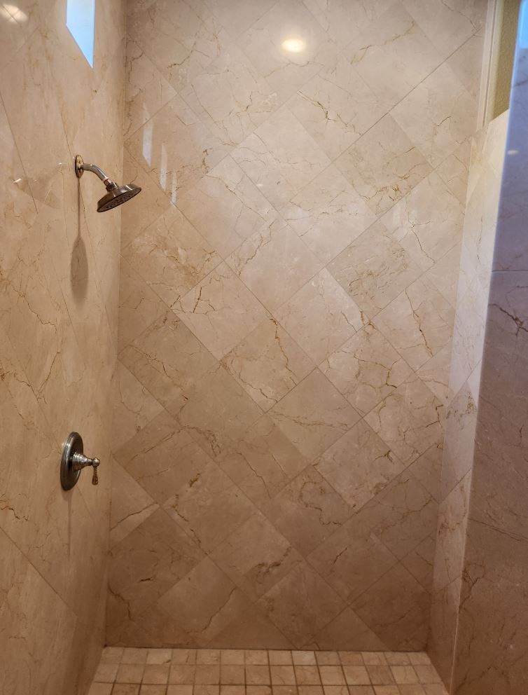 a bathroom with a shower and a tiled floor